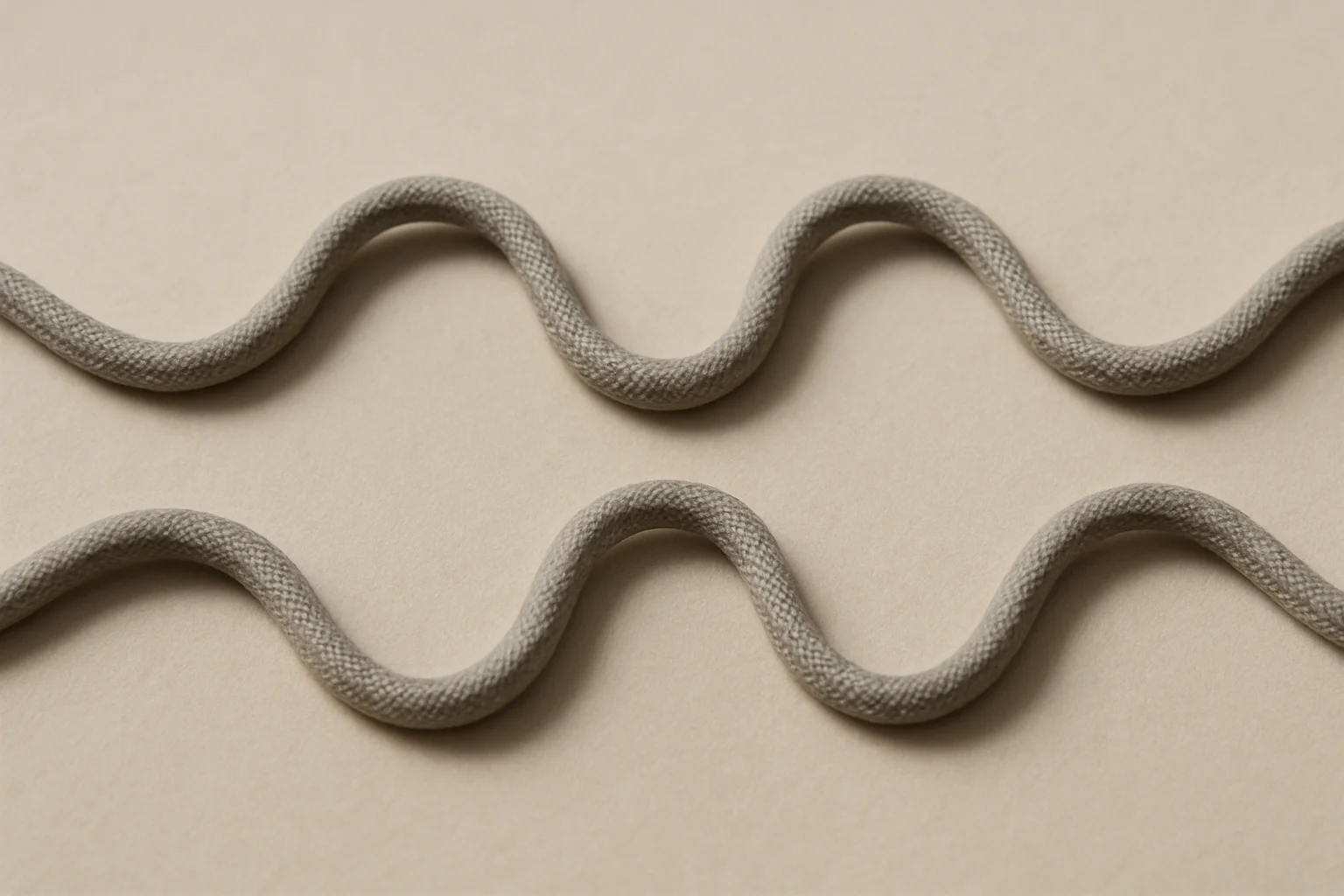Une corde souple posée sur une surface neutre, avec une portion reproduite en sens inverse à côté pour illustrer l’inversion d’une séquence.